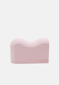 Pink foam yoga block with a curved top shape, smooth texture, and rounded edges. Features embossed brand name "casall" on one side.