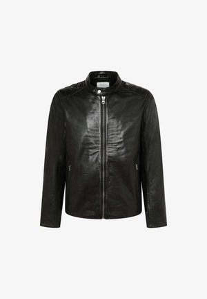 Mustast nahast jakk, millel on tikandiga disain õlgadel, kõrge krae ja keskmine tõmblukk. Omab küljetaskuid ja sujuvat tekstuuri.