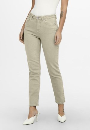 Jeans beige chiaro con una vestibilità slim, vita media, design a cinque tasche e dettagli di cucitura sottili, abbinati a mule bianchi con tacco.