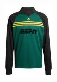 Dugih rukava, zelena i crna majica s V-izrezom, s žutim prugama i logotipom "ESPN" u podebljanom crnom fontu. Izrađena od teksturiranog materijala.