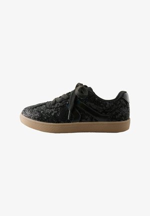 Niski czarny sneaker z czarnymi sznurówkami, cholewką z cekinowej tkaniny, czarnym bocznym detalem i jasnobrązową gumową podeszwą.