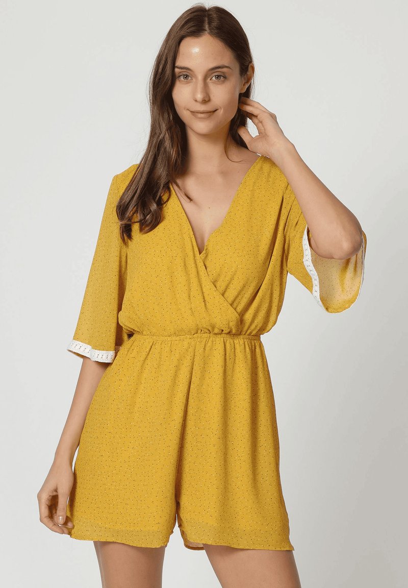 Mono amarillo estilo envolvente con mangas cortas, cintura elástica y borde de encaje blanco en las mangas. Presenta un patrón texturizado en toda su superficie.