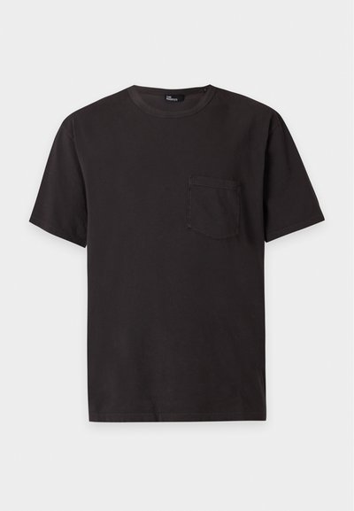T-shirt noir manches courtes col rond avec une petite poche poitrine à gauche, présenté sur un fond gris clair.