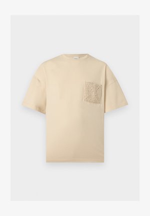 Bézs rövid ujjú póló kerek nyakrésszel és texturált, kötött négyzet alakú zsebbel a bal mellrészen.