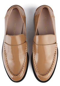 Tan leather loafers with a glossy finish, featuring a stitched accent across the toe and a black rubber sole.