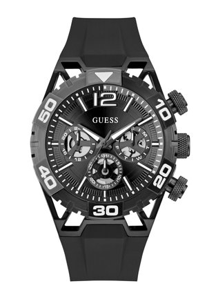 Montre Guess noire avec de grands chiffres blancs, trois sous-cadrans pour l'heure sur 24 heures, le jour et la date, et un bracelet en caoutchouc noir.