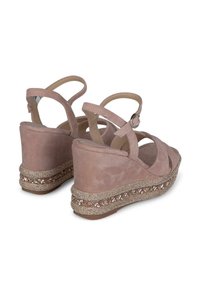 Sandali con zeppa in suede rosa con cinturini alla caviglia, caratterizzati da un accento di gioielli attorno alla base. Punta arrotondata e trama morbida.