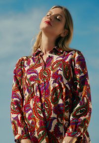 Mehrfarbiges Hemdkleid mit Paisleymuster aus leichtem Stoff, mit durchgehender Knopfleiste, Kragen, langen Ärmeln und gerafftem Taillenbereich.