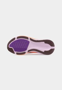 Semelle d'une chaussure de sport orange avec des coussinets de traction violets et noirs, montrant une adhérence texturée et la marque "AIR ZOOM" au centre.