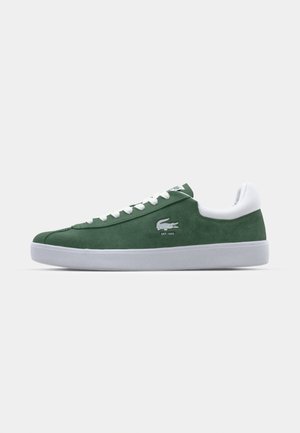 Sneakers verde in suede con suola in gomma bianca, dotati di linguetta e lacci bianchi, e un logo discreto con "EST. 1933" sul lato.