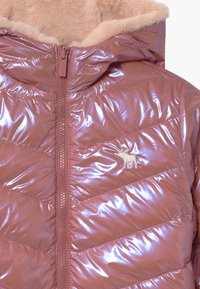 Gewatteerd roze jack met een glanzende afwerking, chevronpatroon en een capuchon gevoerd met beige bont. Voorzien van een ritssluiting aan de voorkant en een klein logodetail.