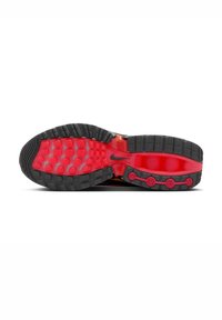 Semelle de sneaker noire et rouge avec du caoutchouc texturé, présentant des crampons circulaires et une zone rouge à motifs. Comprend un détail logo Nike en gris.