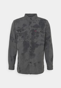 Camicia a maniche lunghe grigia con motivo tie-dye, chiusura con bottoni, due tasche sul petto con patta e design del colletto classico.