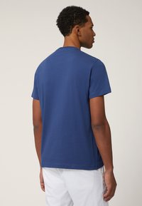 T-shirt in cotone blu navy con maniche corte, scollatura rotonda e vestibilità morbida. Il tessuto appare liscio con cuciture minime.