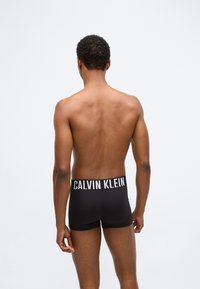 Μαύρα μποξεράκια με φαρδιά λευκή ζώνη που φέρει το λογότυπο "CALVIN KLEIN". Απαλή υφή, εφαρμοστή σχεδίαση και μήκος μέχρι το μέσο του μηρού.