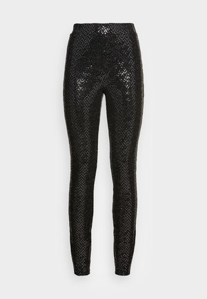Leggings neri con paillettes, caratterizzati da una vestibilità aderente, una texture liscia e una vita alta, che riflettono la luce per un effetto scintillante.