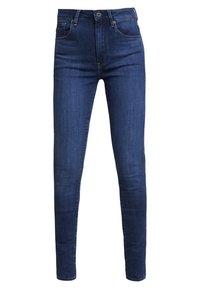 Jeans ajustados de color azul oscuro fabricados en denim, con una cintura alta, cinco bolsillos, pasadores para cinturón y detalles de costura sutiles.