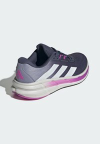 Scarpa da ginnastica viola e grigia con strisce bianche, tomaia testurizzata, colletto imbottito e suola ammortizzata con accenti rosa.