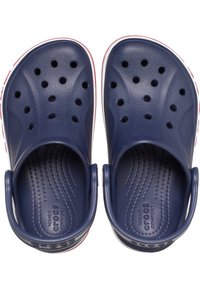 Crocs blu navy con design traforato, texture scanalata, cinturini al tallone e rifinitura bianca lungo la suola. Materiale leggero e flessibile.