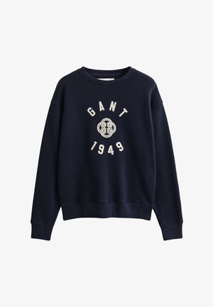 Sweat-shirt bleu marine col rond avec "GANT 1949" et un logo circulaire brodés en blanc sur la poitrine.