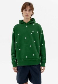 Green hoodie made of cotton, featuring white flower patterns, a front pocket, and a drawstring hood, with "SOL" logo on the chest.