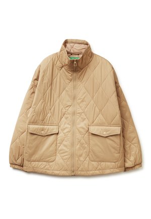 Gequilted beige jack met hoge kraag, ritssluiting aan de voorkant en twee grote drukknopzakken. Zachte textuur en oversized ontwerp.