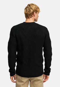 Schwarzer gestrickter Pullover mit einem strukturierten, erhöhten Zickzackmuster, Rundhalsausschnitt und gerippten Bündchen. Hat eine lockere Passform und ist aus weichem Stoff gefertigt.