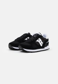Svart sneakers laget av en blanding av mesh og semsket skinn, med hvite detaljer, rund tå, tykk såle og svarte snøringer. Klassisk design med logo.