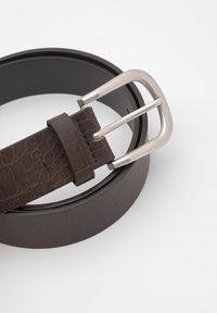 Brązowy skórzany pasek o fakturze krokodyla, z metalową klamrą w kolorze srebrnym oraz pętlą do regulacji.