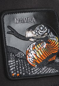 Schwarzer Patch mit einer detaillierten gestickten Schlange in orange-weißen Mustern; das Wort "MAMBA" ist über dem Bild gestickt.