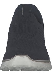 Zapato negro de punto sin cordones con un upper texturizado, un talón reforzado y una suela de goma blanca con un dibujo en la banda de rodadura.