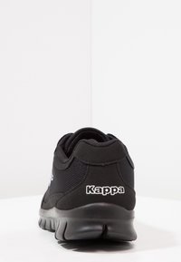 Svart idrottssko med överdel i mesh och vadderad krage. Har en tjock gummisula och vitt "Kappa"-logotyp på hälen.