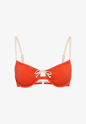 Orange bikinitop med polstrede skåle, justerbare cremefarvede stropper, et centralt bindedetalje og en metal spænde bagpå. Blød tekstur.