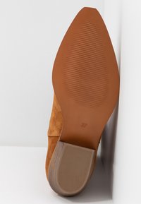Zamszowe szpilki w kolorze camel z gładkim, spiczastym noskiem i teksturowaną gumową podeszwą. Rozmiar 37 oznaczony na podeszwie.