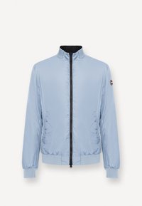 Hellblaues Reißverschluss-Jacke mit Stehkragen, elastischen Bündchen und Bund, mit einem kleinen runden Logoaufnäher am linken Ärmel.