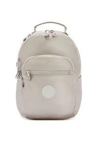 Sac à dos en tissu beige avec une texture lisse, forme arrondie, poche avant zippée et écusson logo. Dispose d'une poignée supérieure et de ferrures argentées.