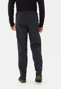 Pantaloni grigio scuro, resistenti all'acqua, con vita e polsini aderenti, dotati di aperture laterali con zip e cuciture rinforzate per una maggiore durata.
