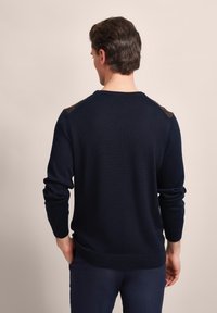 Marineblauer Strickpullover mit Rundhalsausschnitt, Slim Fit und strukturierten Schulterakzenten. Verfügt über lange Ärmel und einen gerippten Saum.