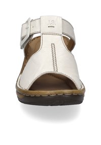 White leather sandal with an open toe design, adjustable strap, stitched detailing, and a brown rubber sole. Soft texture and casual style.