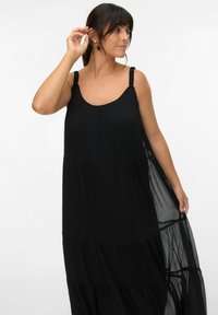 Robe noire sans manches au coupe décontractée, dotée de bretelles froncées et de superpositions de panneaux transparents pour une silhouette fluide.