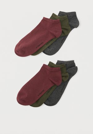 Trois paires de chaussettes basses en bordeaux, vert olive et gris charbon, empilées avec le texte de la marque visible sur chaque paire.