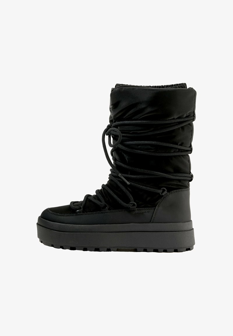 Černá zateplená boot s volnějším designem, vybavená texturovaným textilním svrškem a silnou gumovou podrážkou. Nastavitelná šňůrková patka pro lepší přizpůsobení.