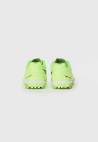 Par de zapatillas deportivas de color verde neón con suelas texturizadas y la marca "EVOLUTION", vistas desde la parte trasera sobre un fondo blanco liso.