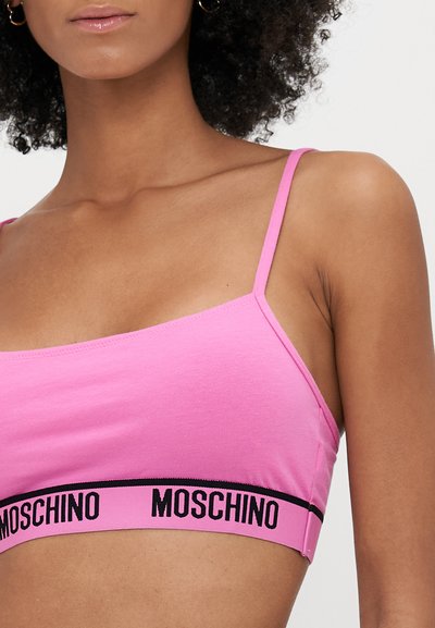 Rózsaszín bralette puha pamutból, vékony pántokkal és ellentétes fekete szalaggal, rajta a "MOSCHINO" felirattal. Simaság, testhezálló kialakítás.