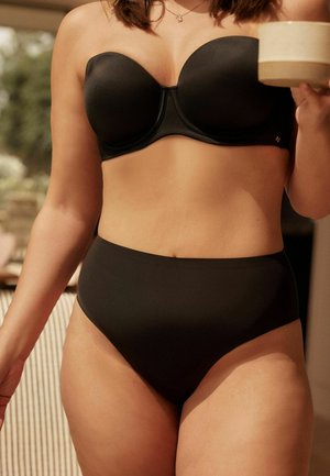 Zwart gemodelleerde strapless beha van soepel materiaal, gecombineerd met zwarte high-waisted slips. Beide items hebben een strakke, naadloze uitstraling.