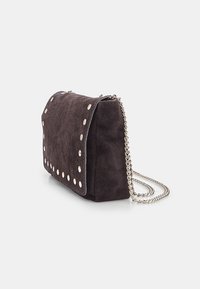 Borsa scura in suede con borchie argentate lungo il bordo e tracolla a catena. Presenta una chiusura a patta e una superficie morbida e testurizzata.