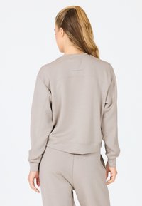Sweat-shirt gris clair en matériau de sweat-shirt, avec une coupe décontractée, des épaules tombantes et un petit logo "ENDURANCE" dans le dos.