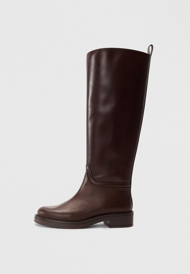 Botte en cuir marron, montante jusqu'au genou, avec une finition lisse, un bout arrondi, un petit talon carré et de simples coutures le long de la tige.