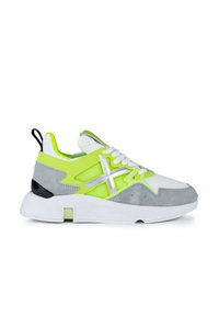 Zapatilla deportiva con parte superior de ante gris, malla verde neón y sintético blanco. Presenta una suela blanca y detalles en plateado. Incluye una lengüeta trasera oscura.