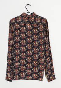 Camicia a maniche lunghe floreale con fondo blu navy. Presenta piccoli fiori in rosso, giallo e rosa, con colletto e polsini con bottoni. Tessuto morbido.
